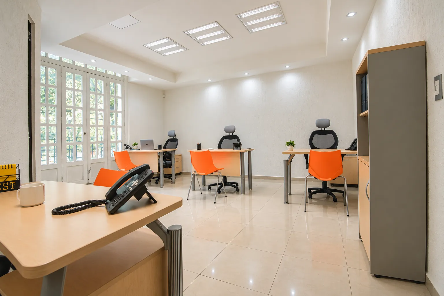 Oficina amplia con escritorios, sillas naranjas y ventanales, OfiRent Condesa, Ciudad de México