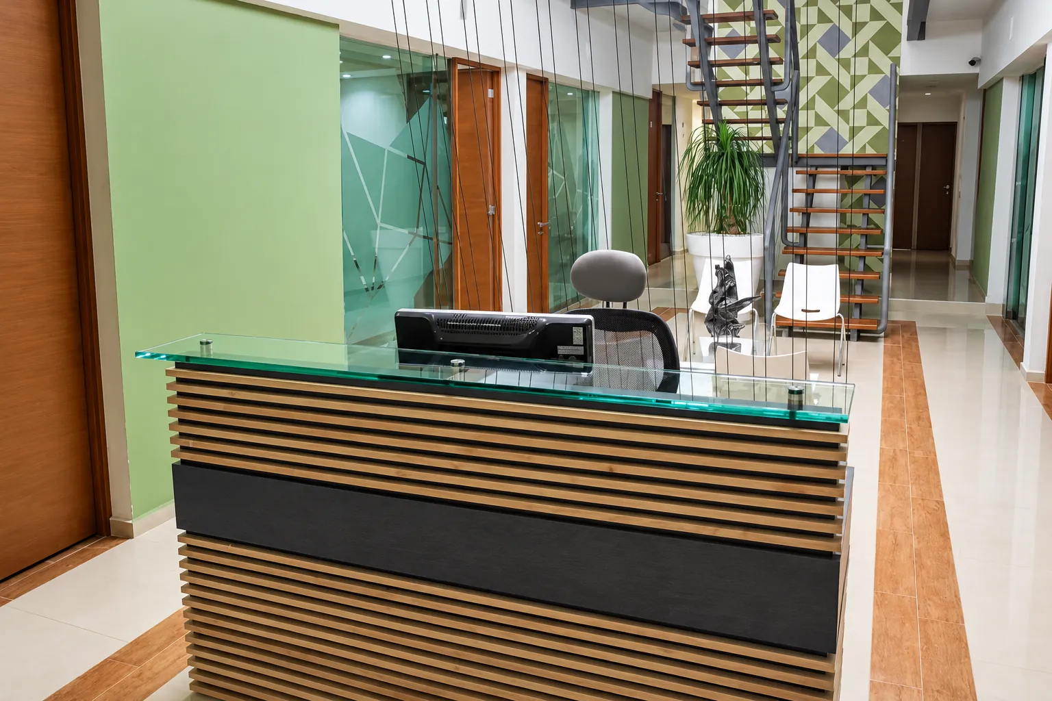 Recepción con mostrador de madera y cristal y escalera al fondo, OfiRent Condesa, Ciudad de México