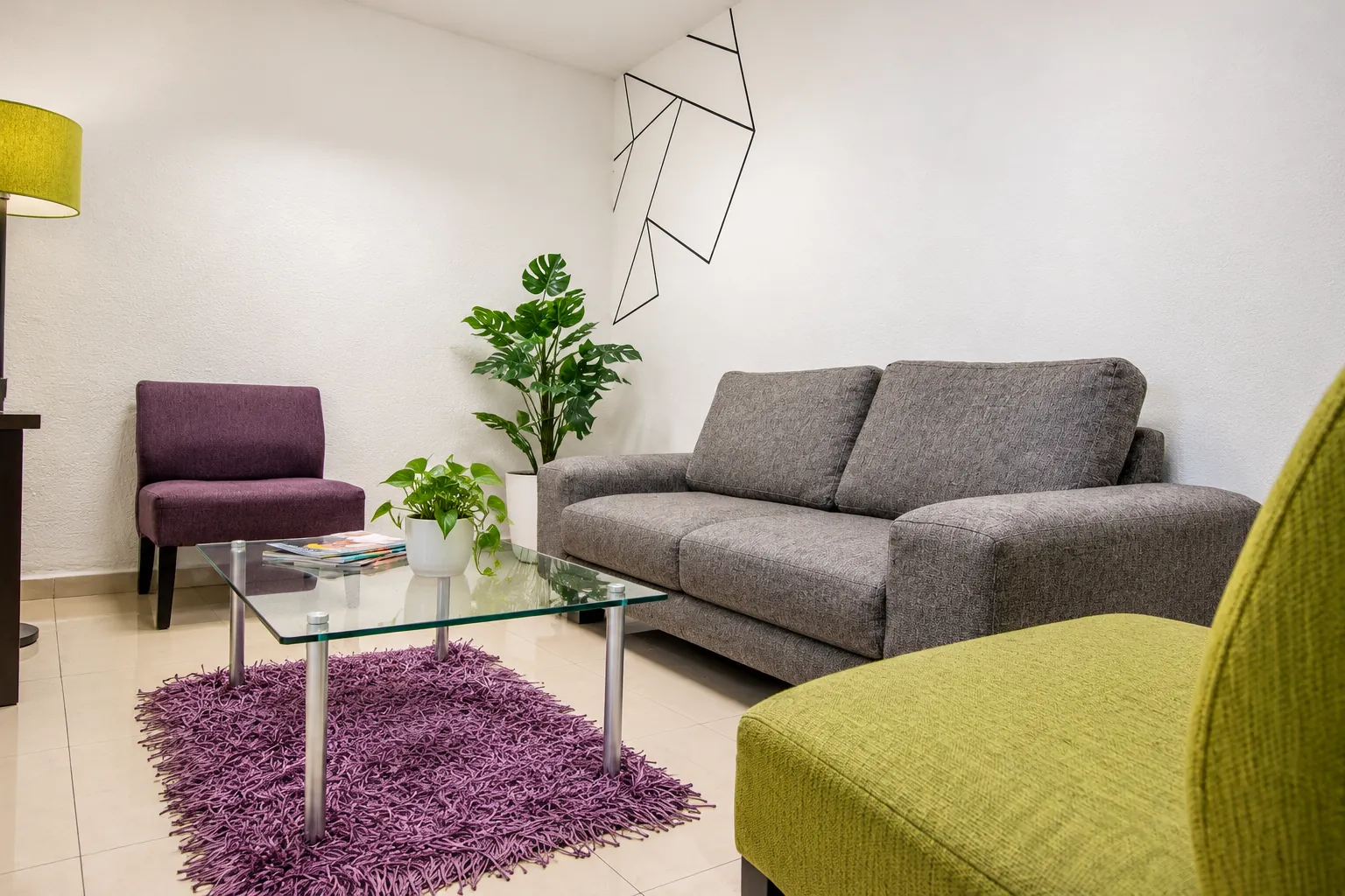 Sala de espera con sofá gris, mesa de centro y plantas, OfiRent Condesa, Ciudad de México