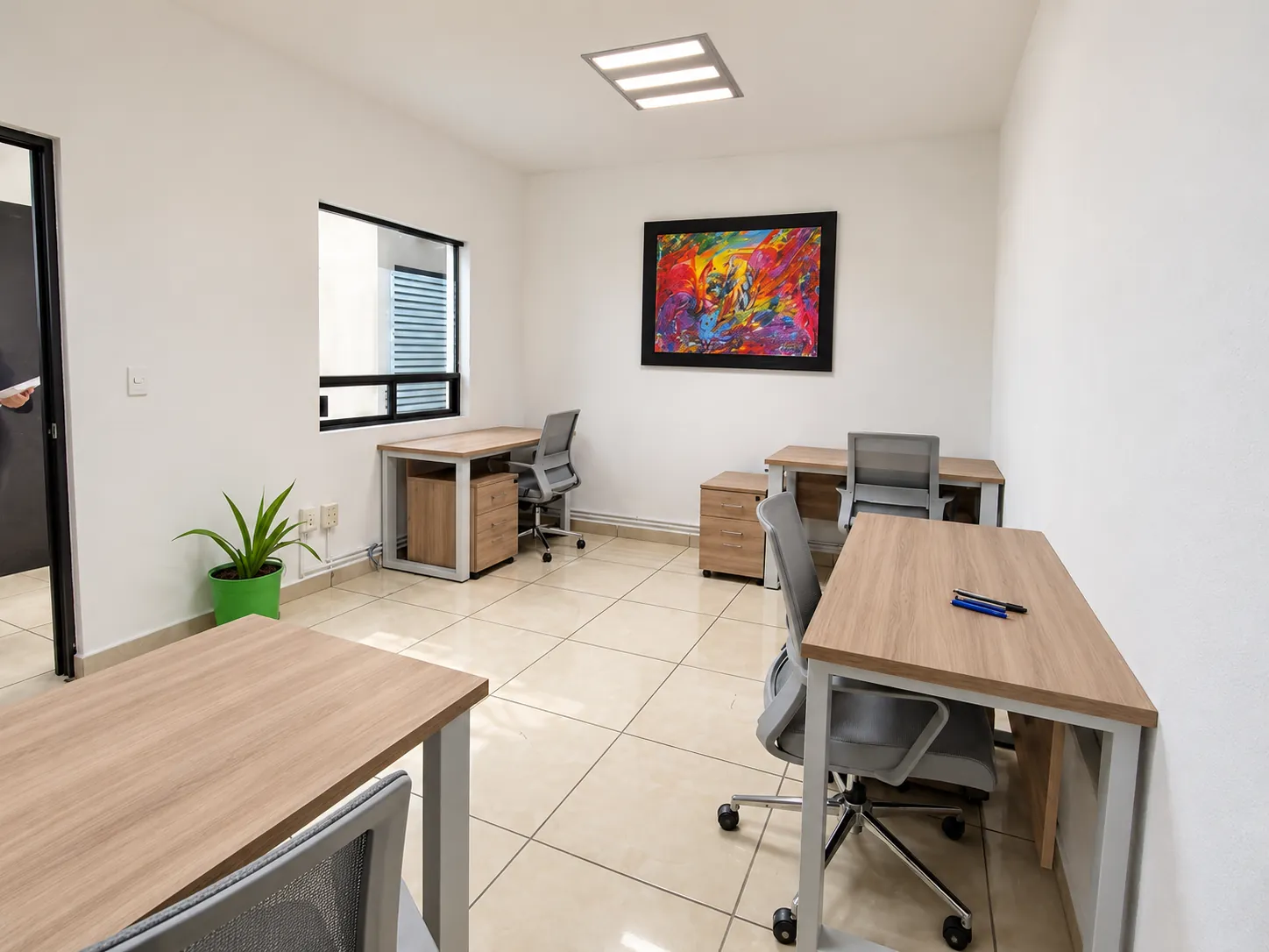 Oficina con escritorios de madera, silla ergonómica y un cuadro de colores, OfiRent Cuauhtémoc (Río Po), Ciudad de México