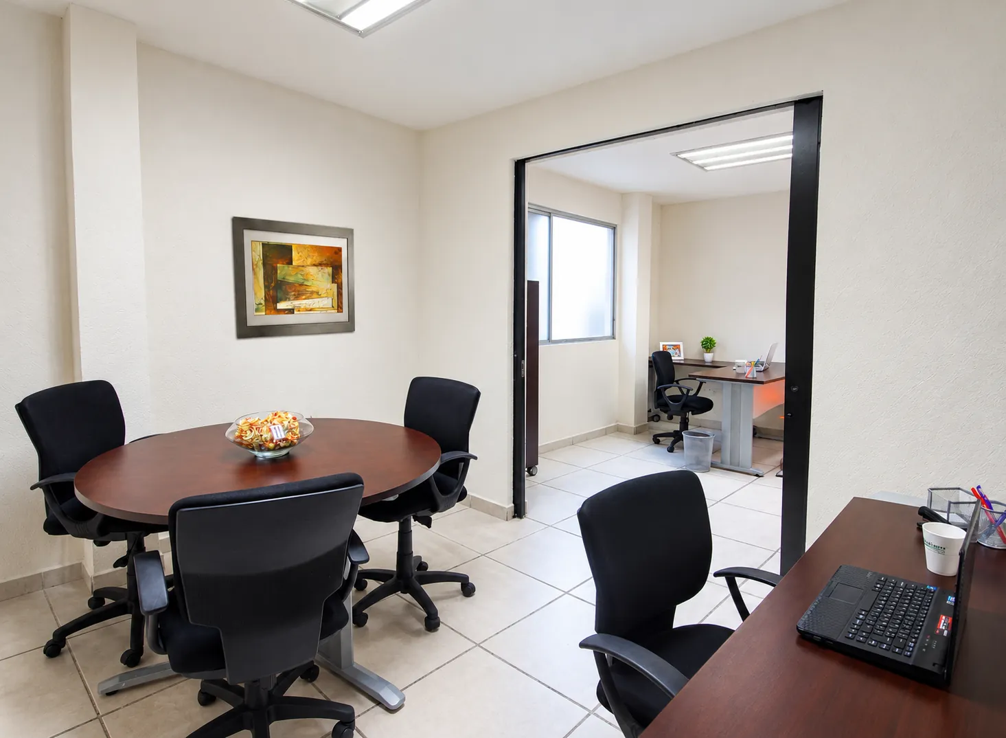 Oficina con mesa de reuniones redonda y área de trabajo al fondo, OfiRent Cuauhtémoc (Río Po), Ciudad de México