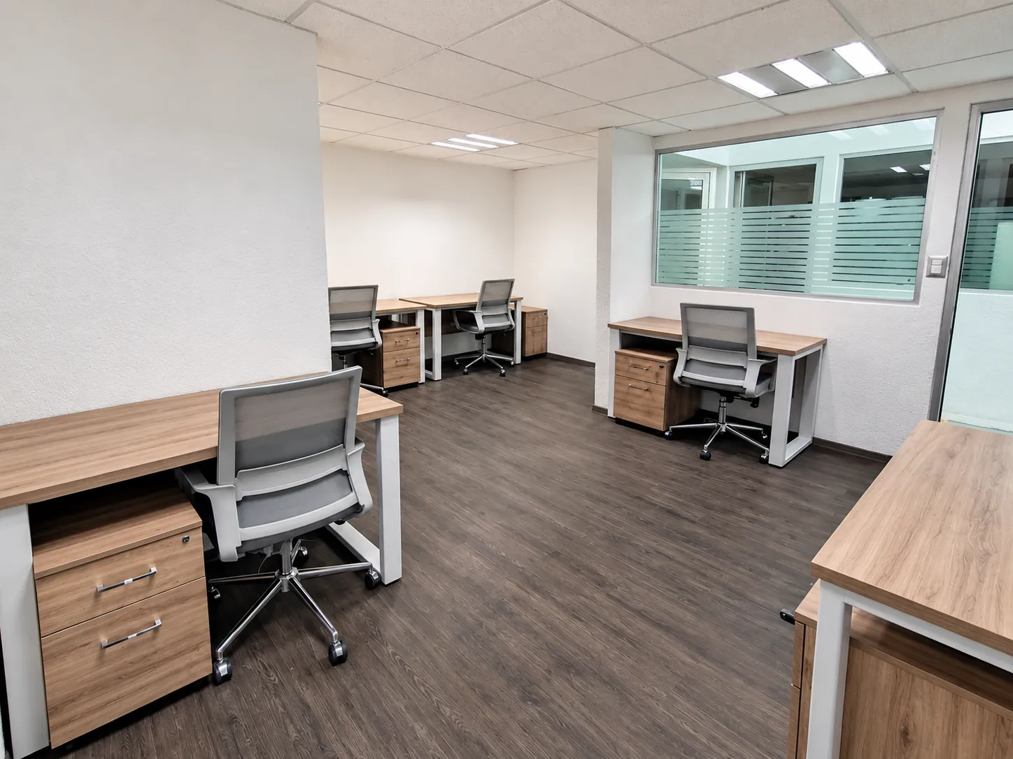 Oficina con escritorios de madera clara, archiveros y piso oscuro, OfiRent Nápoles, Ciudad de México