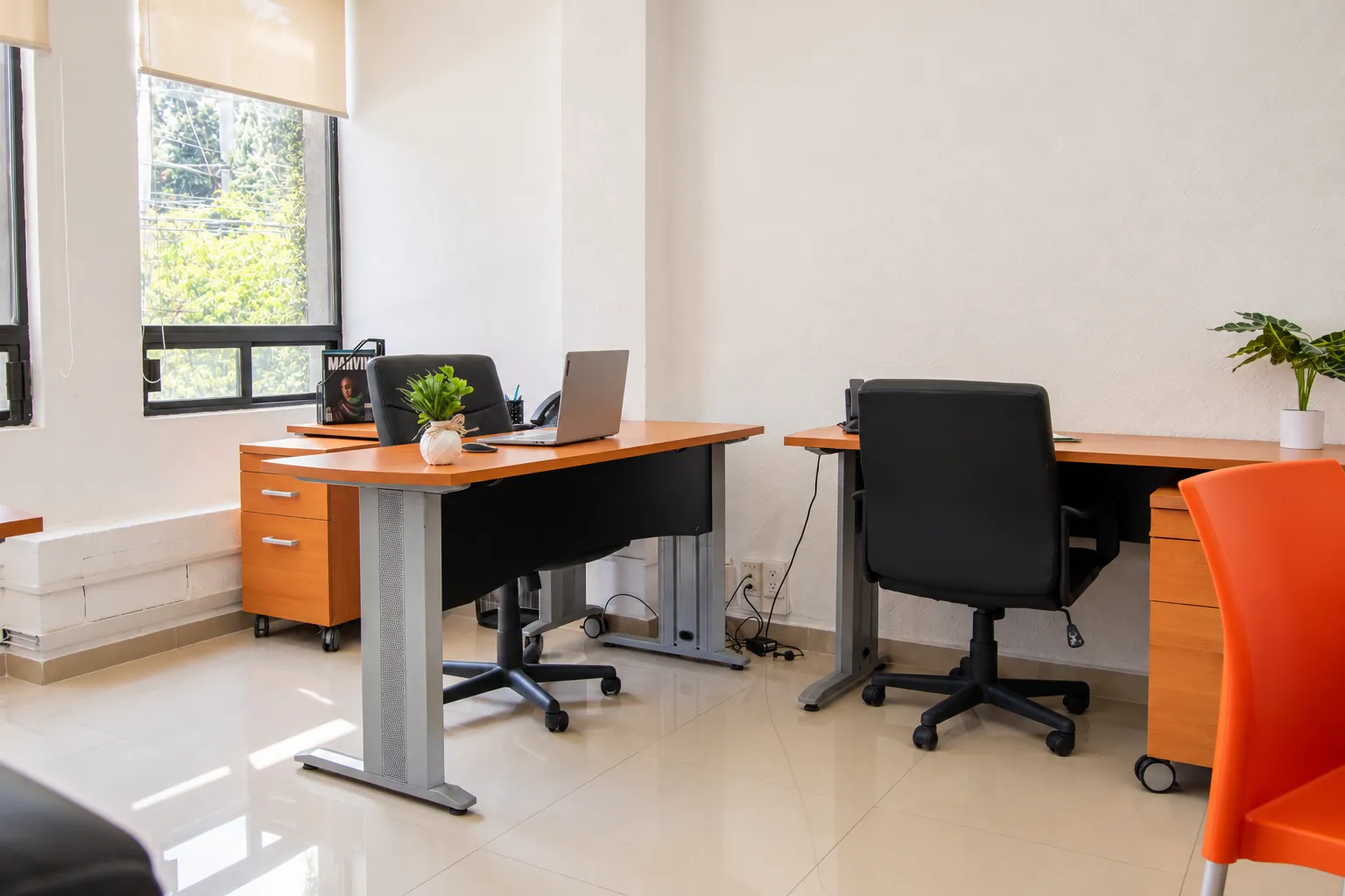 Oficina con escritorios de madera, ventana y silla naranja, OfiRent Narvarte, Ciudad de México