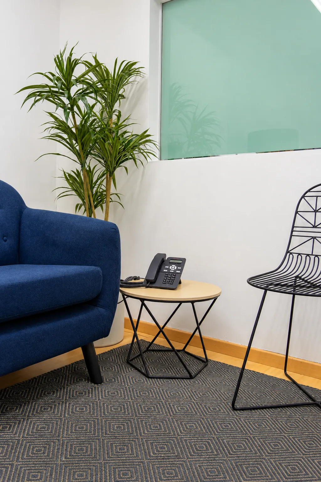 Rincón con sillón azul, mesa auxiliar y teléfono, OfiRent Narvarte, Ciudad de México