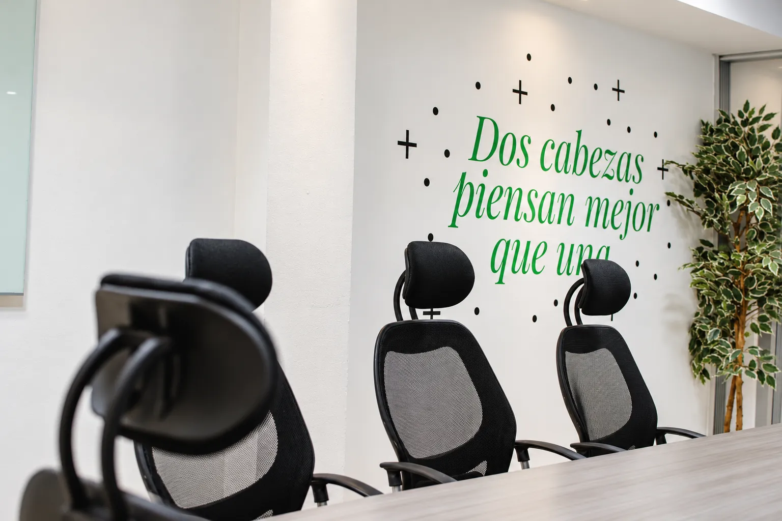 Sala de reuniones con sillas ergonómicas y una frase en la pared, OfiRent Narvarte, Ciudad de México