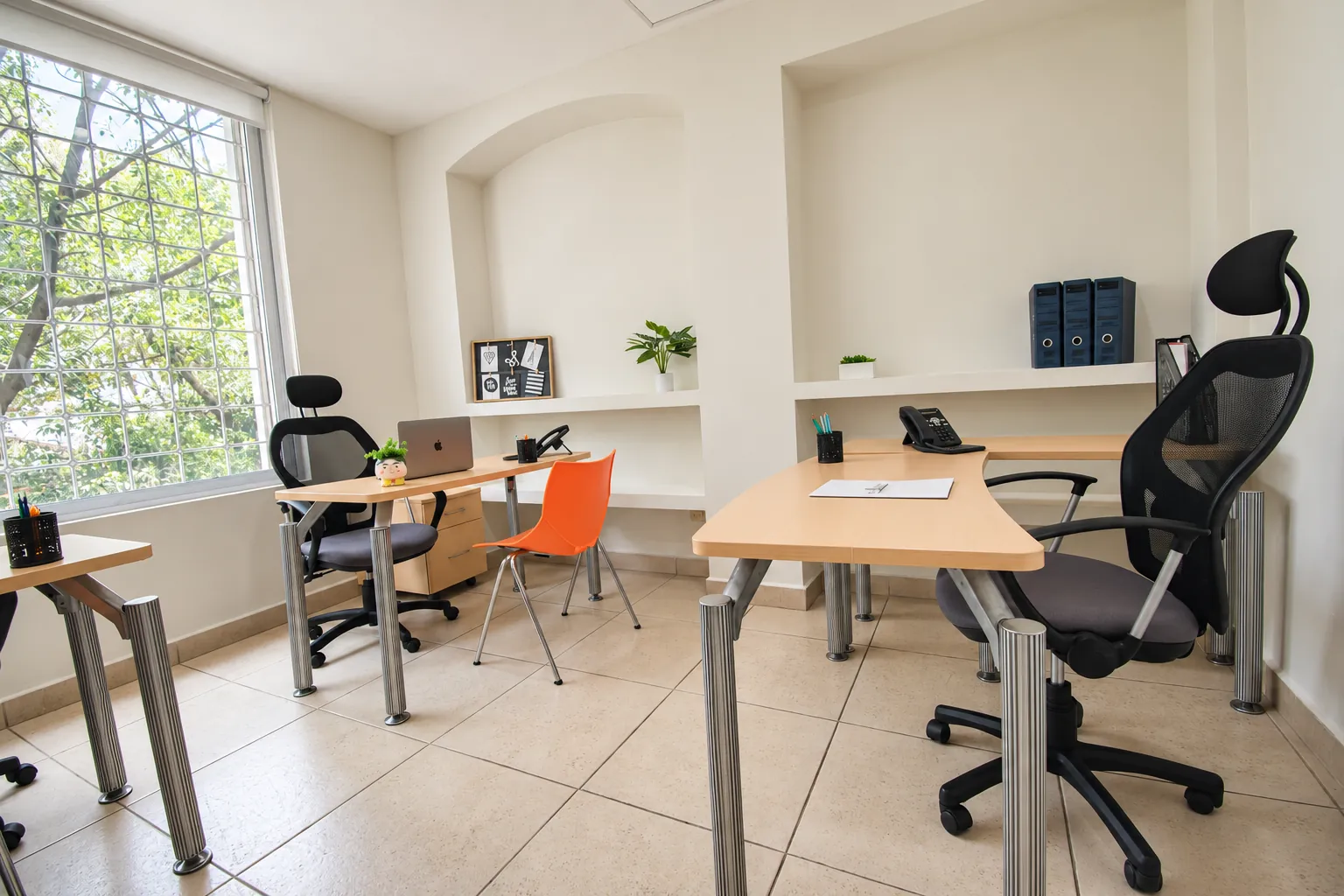 Oficina con escritorios de madera, sillas ergonómicas y ventanas con vista a los árboles, OfiRent Roma, Ciudad de México
